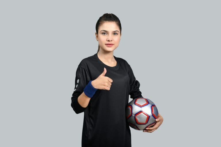 Product photo layer: woman in a black long-sleeve training top holding a football